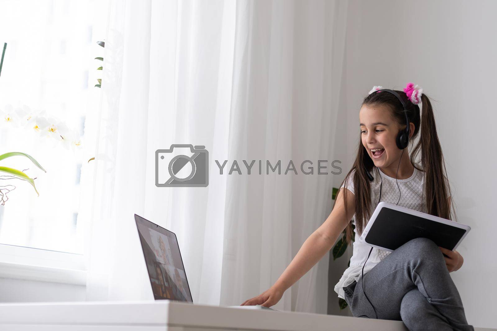 Royalty free image of A young girl is attending online school or classes. Study in lock down as Schools closed due to Covid-19. Role of technology during nationwide lock down. Learning at home concept by Andelov13