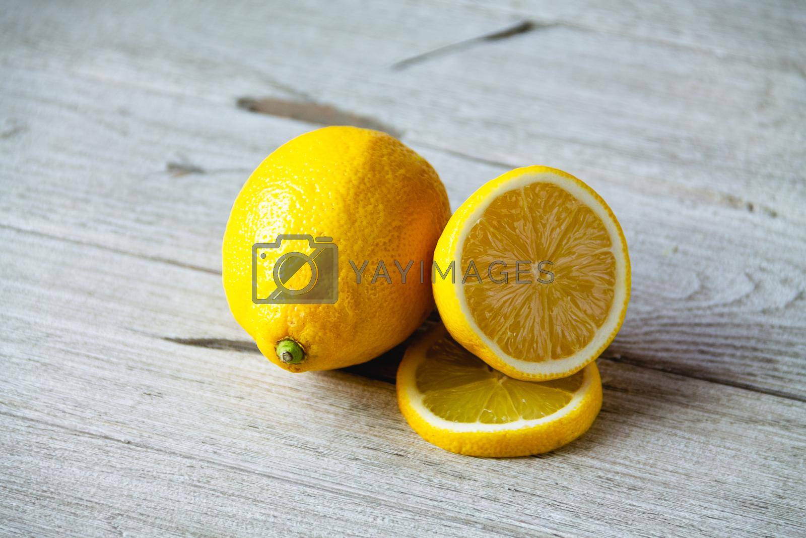 Royalty free image of fresh sliced lemon on wooden natural background by Ostanina