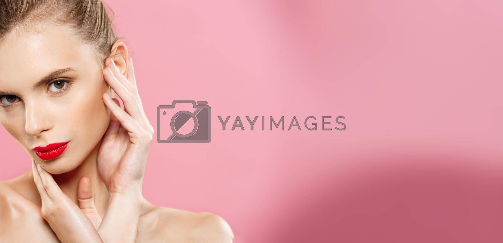 Beauty concept - Gorgeous Young Brunette Woman face portrait. Beauty Model Girl with bright eyebrows, perfect make-up, red lips, touching her face. Isolated on pink background