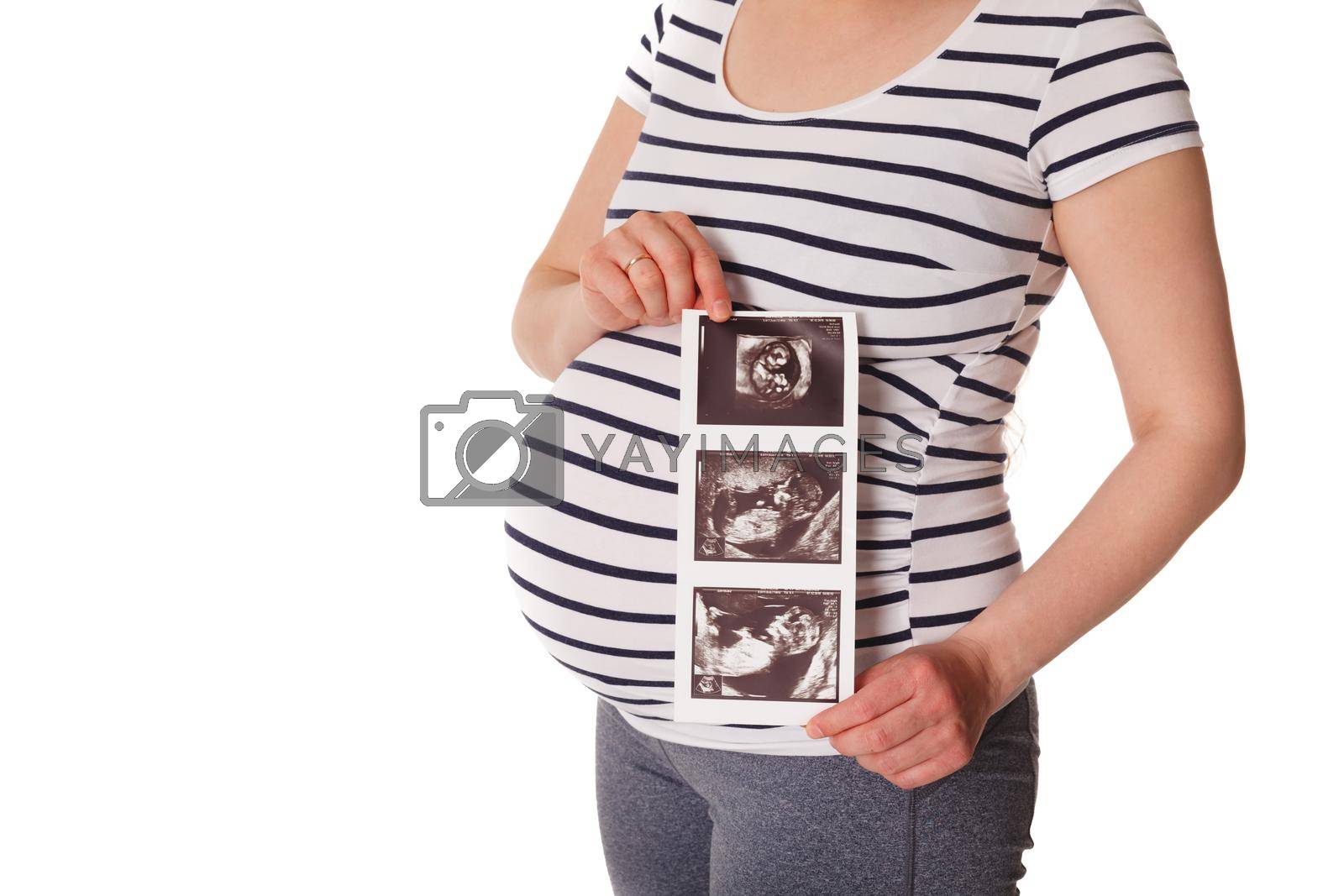 Royalty free image of Pregnant woman standing and holding her ultrasound baby scan by dimol