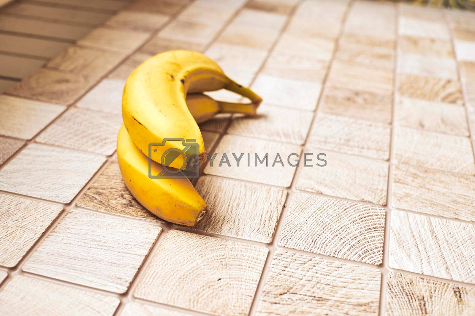 Royalty free image of Two ripe bananas on a checkered wooden surface by jovani68