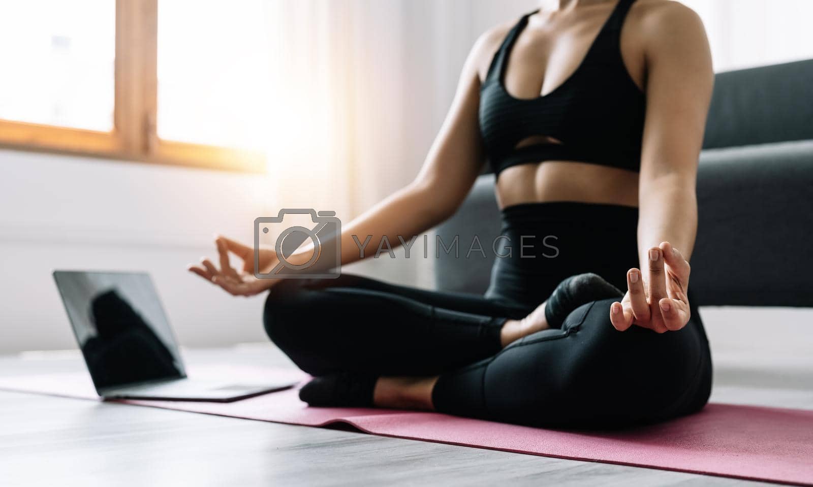 Young woman exercising, asian woman practicing meditation indoors from laptop, Yoga and Healthy lifestyle concept