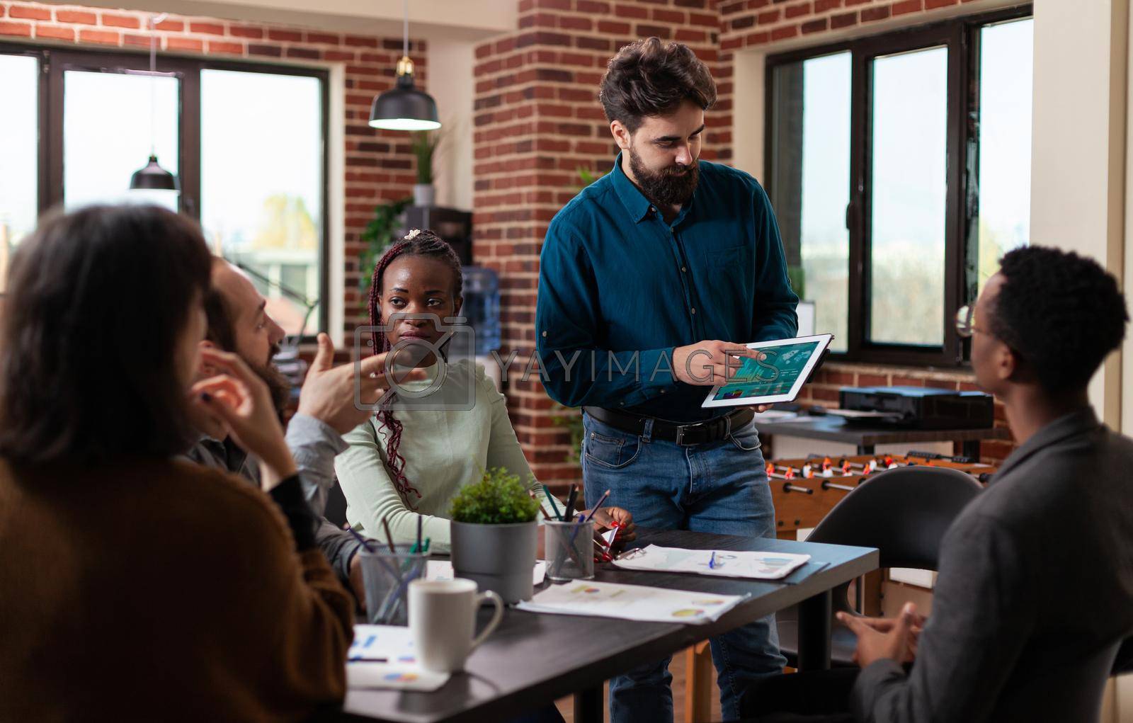 Businessman presenting company turnover during business meeting in startup office working at marketing strategy. Multiethnic businesspeople brainstorming ideas for management project