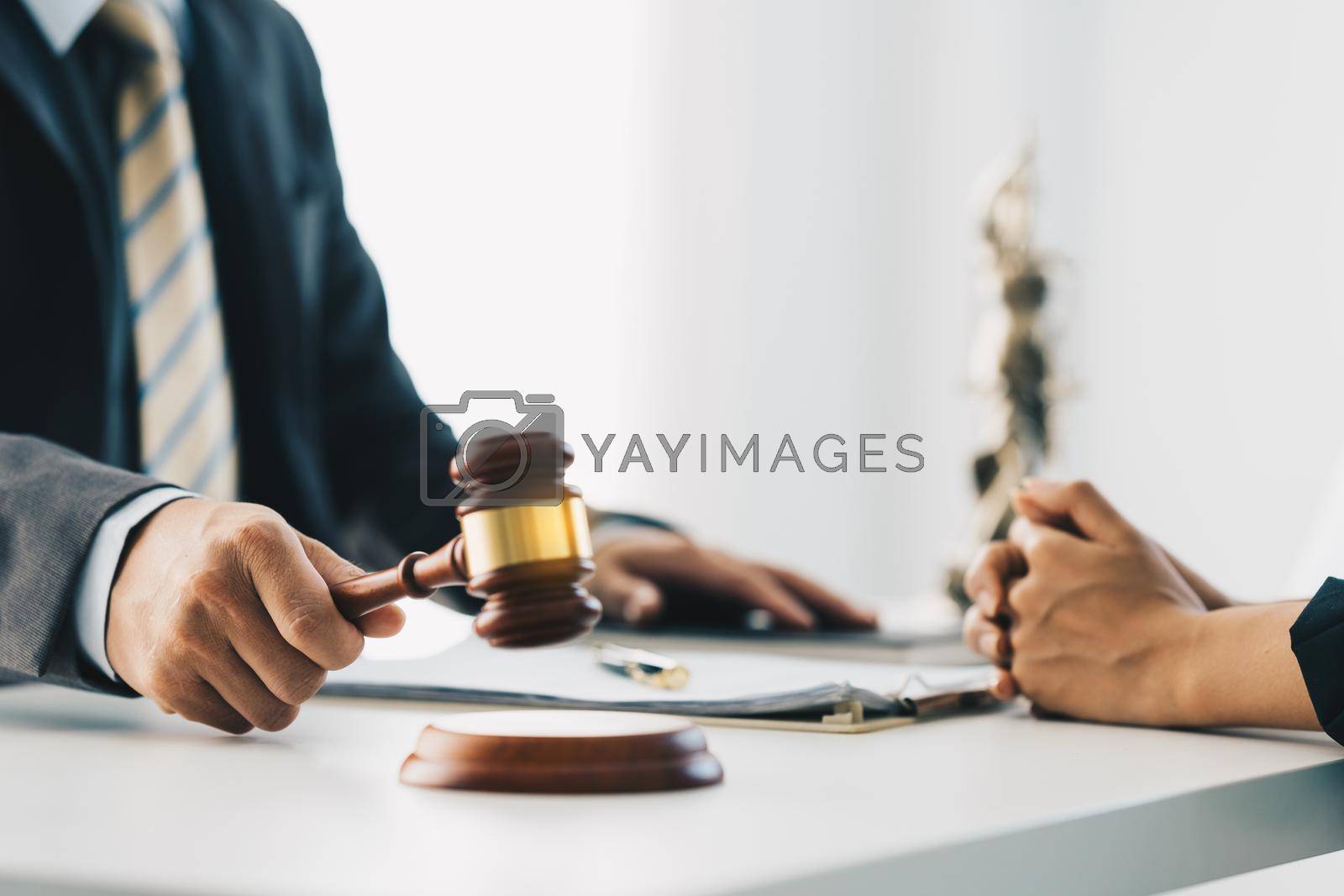 Royalty free image of Business woman and lawyers discussing contract papers with brass scale on wooden desk in office. Law, legal services, advice, Justice concept. by itchaznong