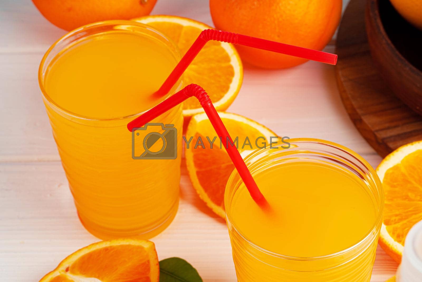 Royalty free image of Glass of orange juice with red straw on table by Fabrikasimf