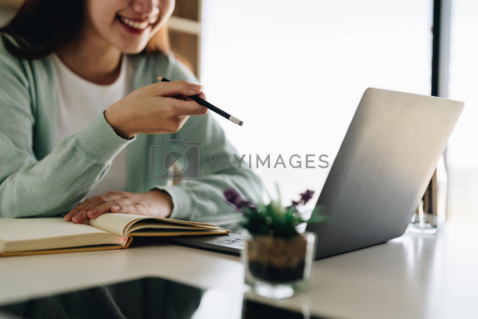 Royalty free image of Concentrate asian gial freelancer wearing headset, communicating with client via video computer call. Millennial pleasant professional female tutor giving online language class. by nateemee
