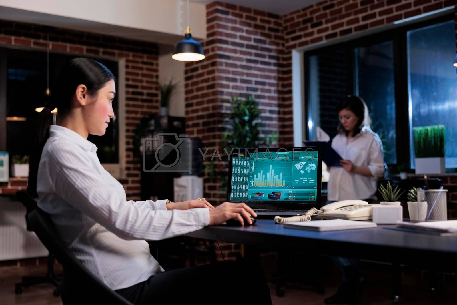 Business company executive manager analyzing management charts and financial graphs in office workspace. Agency accountant sitting at desk while using laptop to review marketing strategy output.