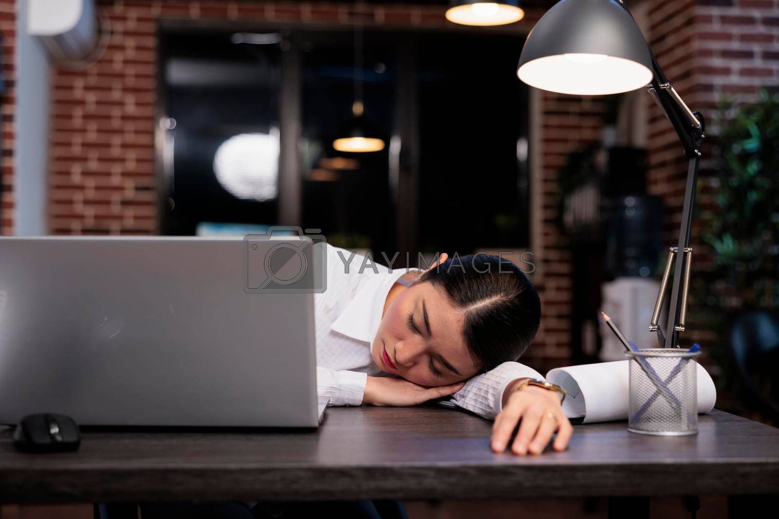 Royalty free image of Fatigued business company employee sleeping on desk because of overtime working hours at night. by DCStudio