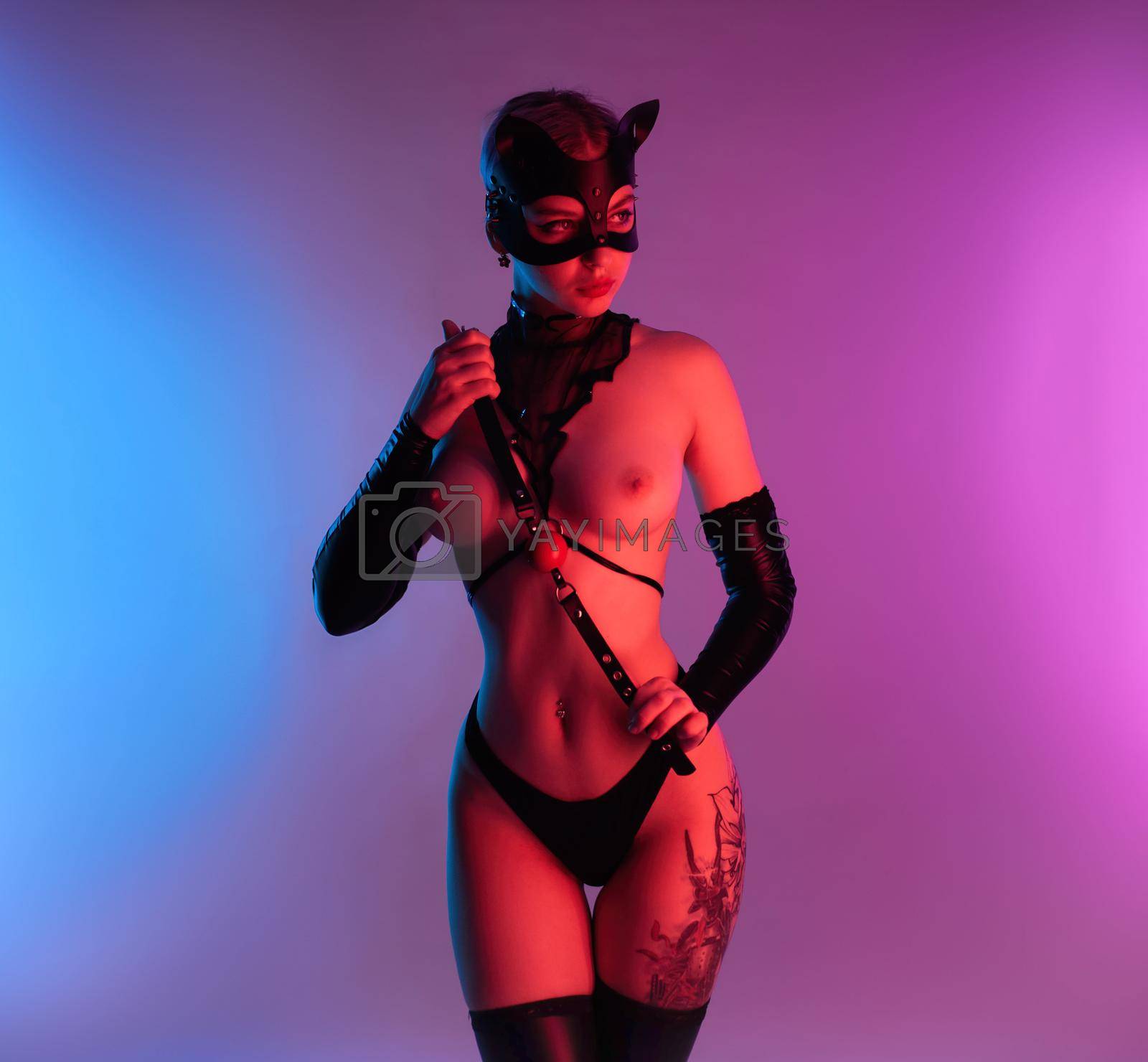 Royalty free image of sexy woman in a leather cat mask with a gag for bdsm sex toys by Rotozey