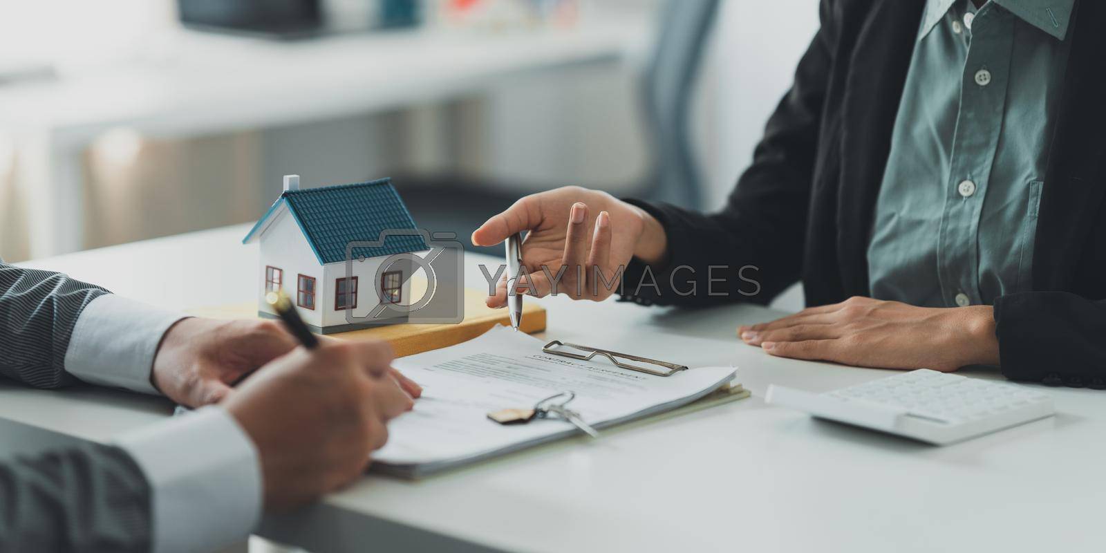 Royalty free image of Close up Business woman or Real Estate agent explain signing agreement for buying house. Bank manager and real estate concept. by itchaznong