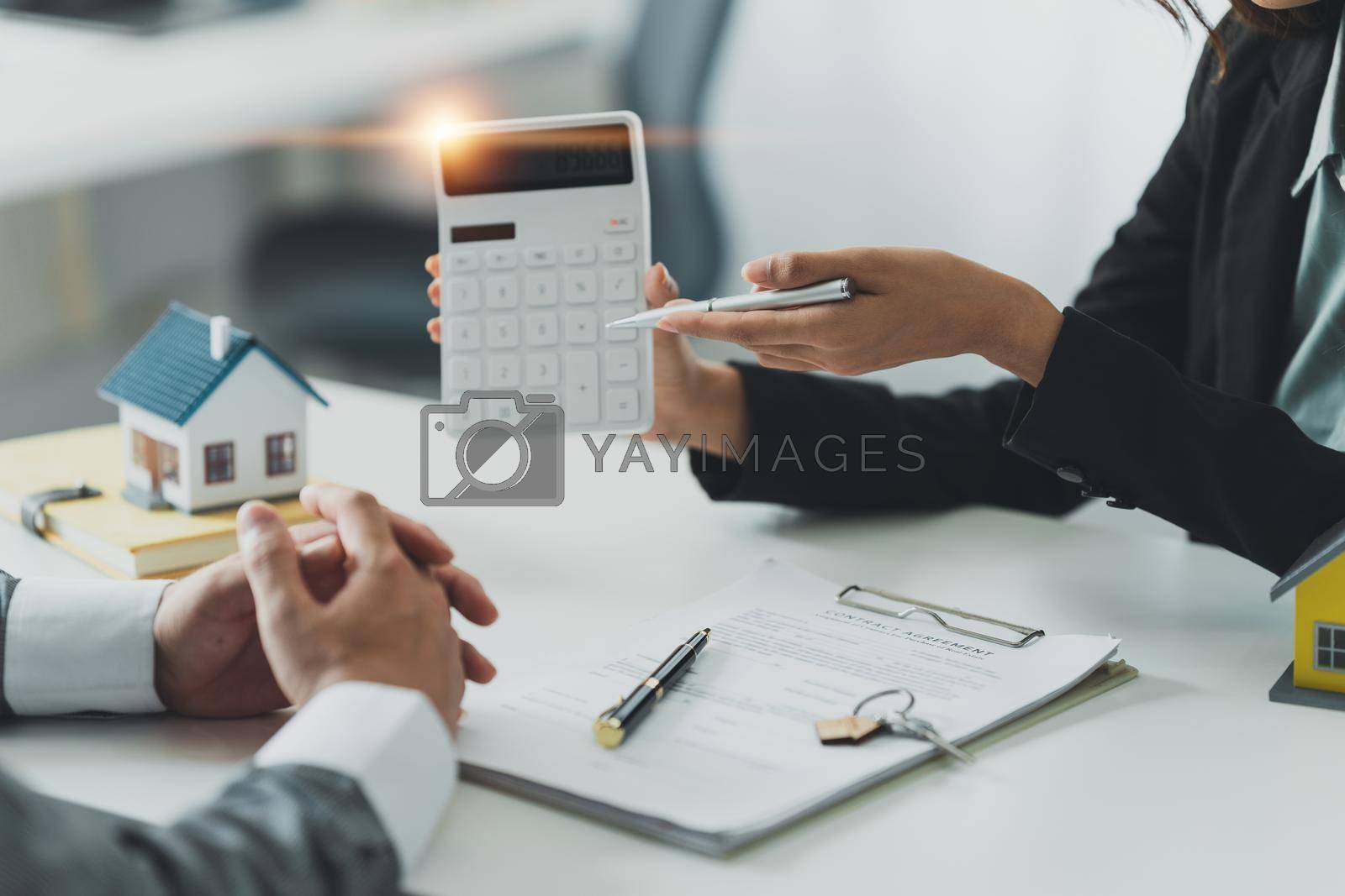 Royalty free image of Close up Business woman or Real Estate agent explain signing agreement for buying house. Bank manager and real estate concept. by itchaznong