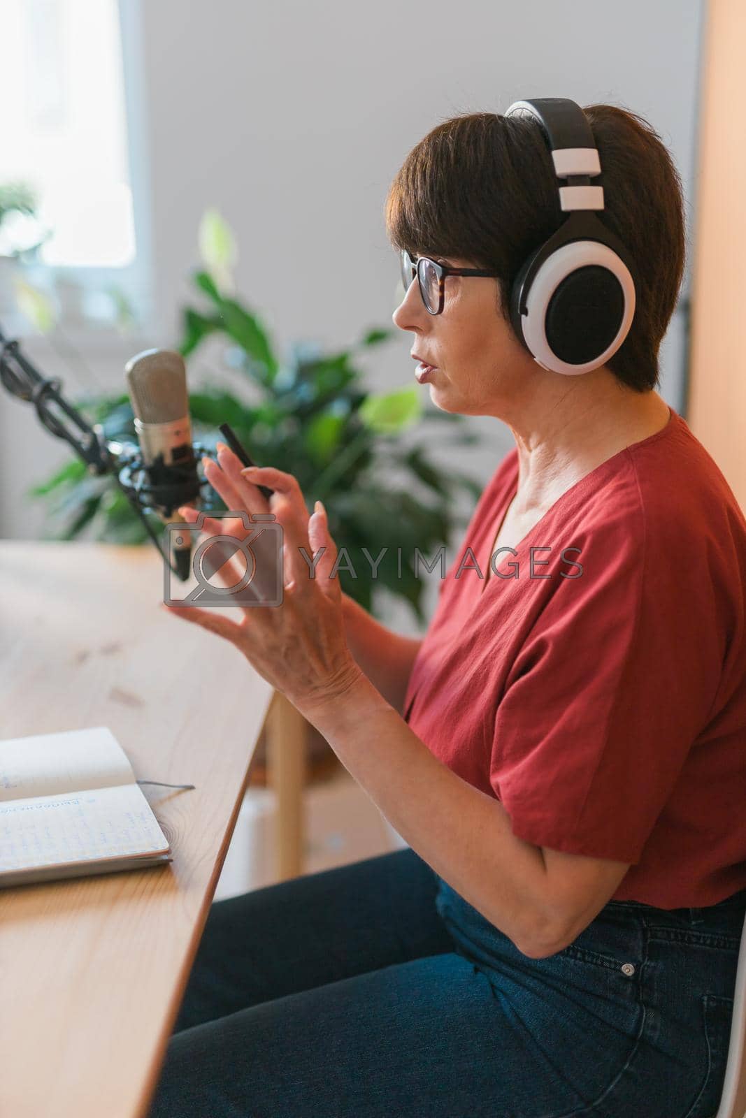 Royalty free image of Middle-aged woman radio host making podcast recording for online show - broadcast and dj concept by Satura86