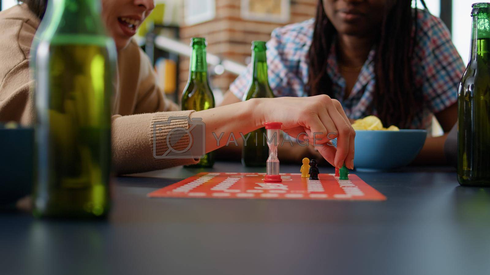 Diverse group of friends playing charades board games and fun gathering, enjoying leisure activity with cards and figurines. People laughing and having fun with competitive gameplay. Close up.