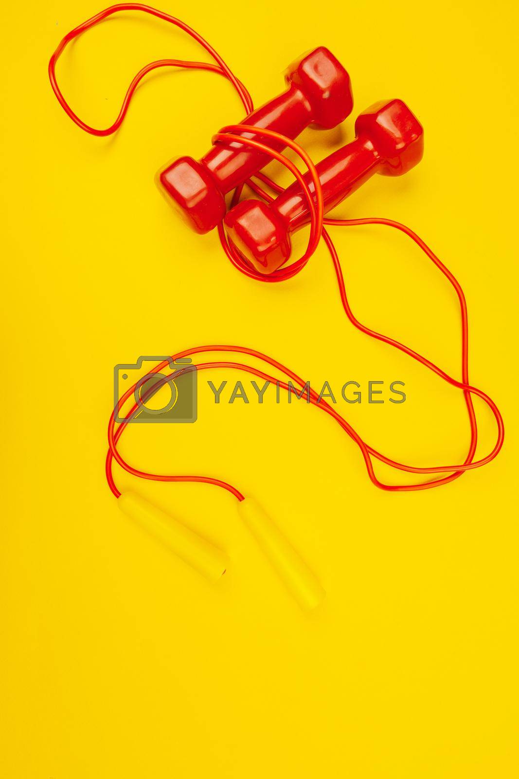 Fitness dumbbells on bright yellow background. Fitness concept. Close up.