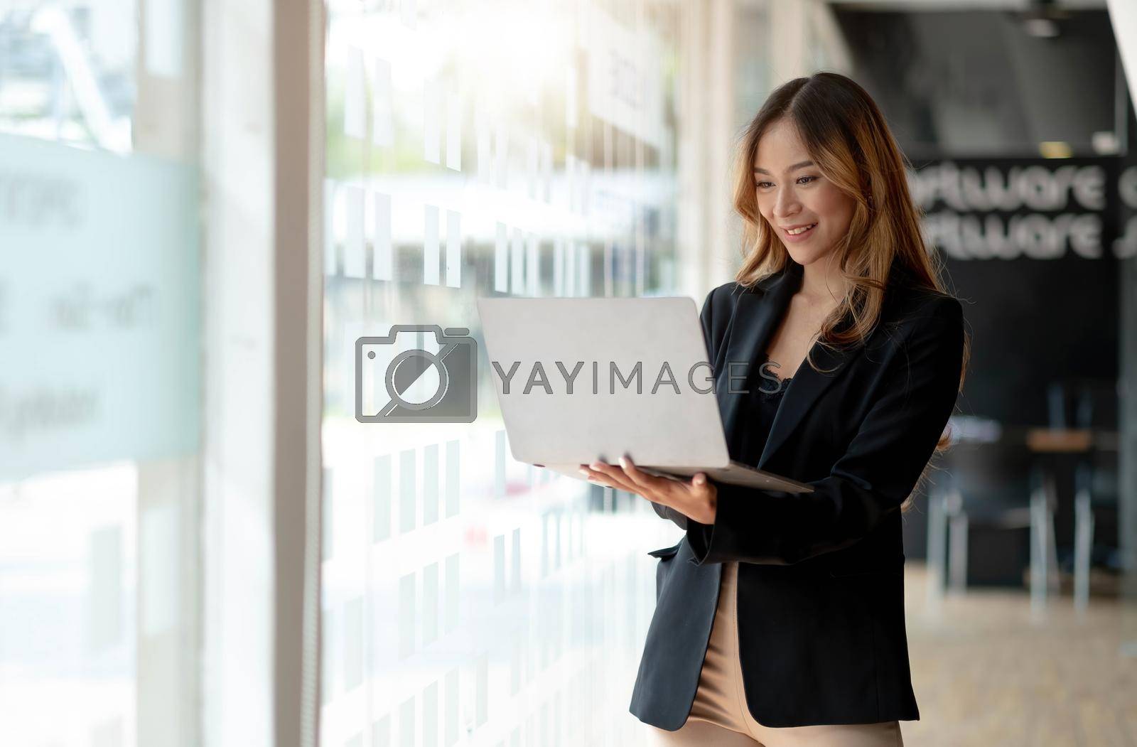 Royalty free image of Young Asian business woman working online on a laptop by wichayada