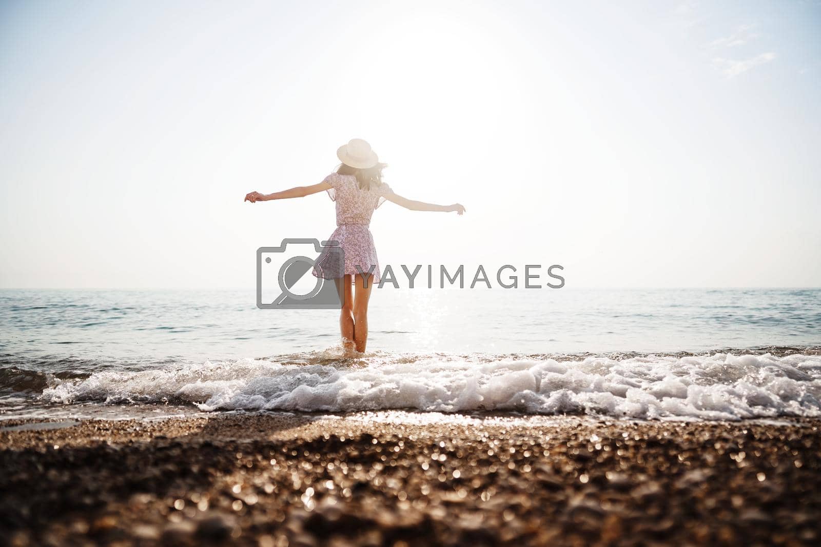 Royalty free image of Lonely young woman walks on the seashore at sunset by Fabrikasimf