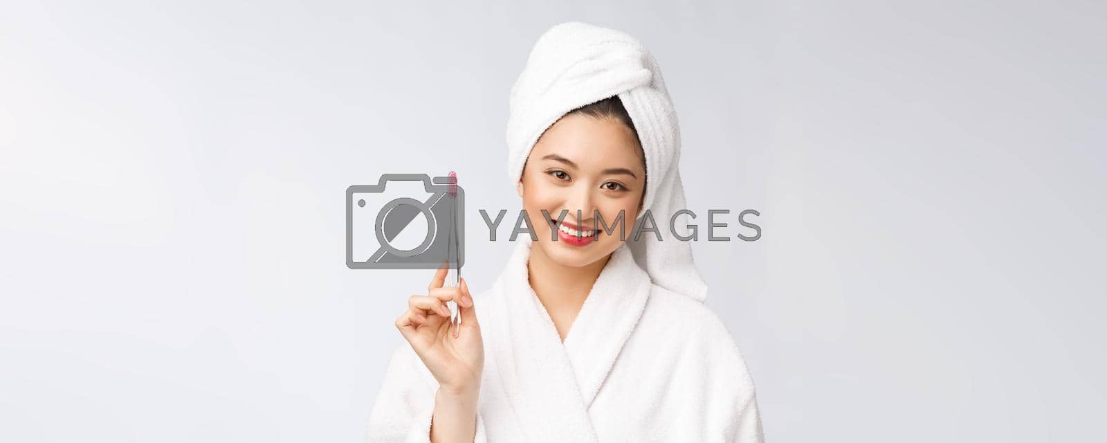 Royalty free image of Asian happy woman with toothbrush in bathrobe morning mood by Benzoix