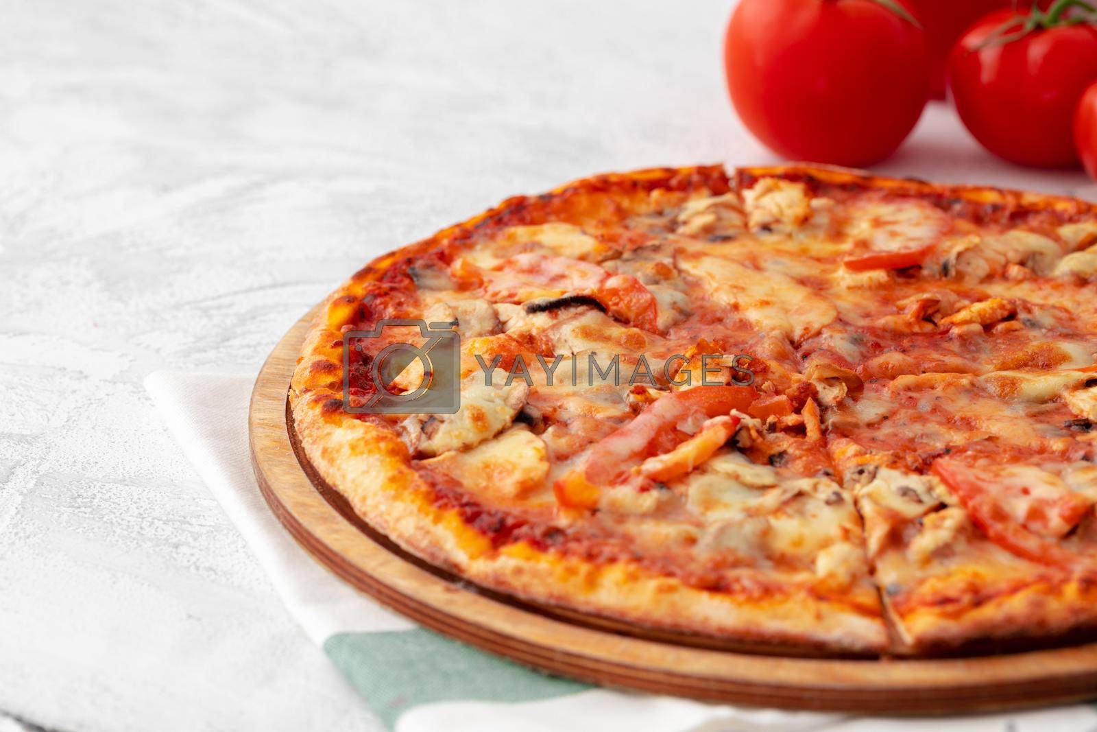 Royalty free image of Freshly baked pizza on table close up by Fabrikasimf