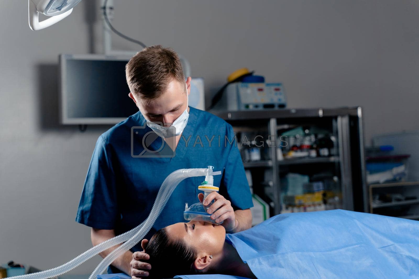 Royalty free image of Anesthesiologist making ingalation anesthesia for patient. Doctor puts a mask on the patient before starting operation by Rabizo
