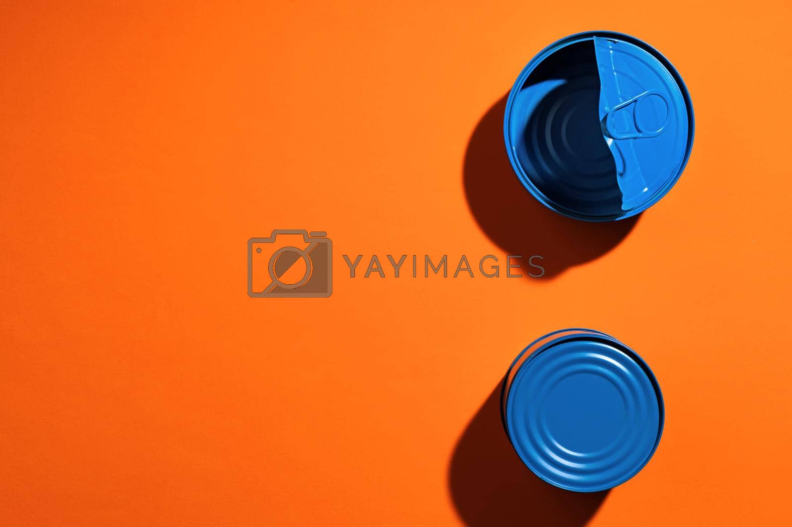 Royalty free image of Aesthetic concept with blue painted tin can on orange background by Fabrikasimf