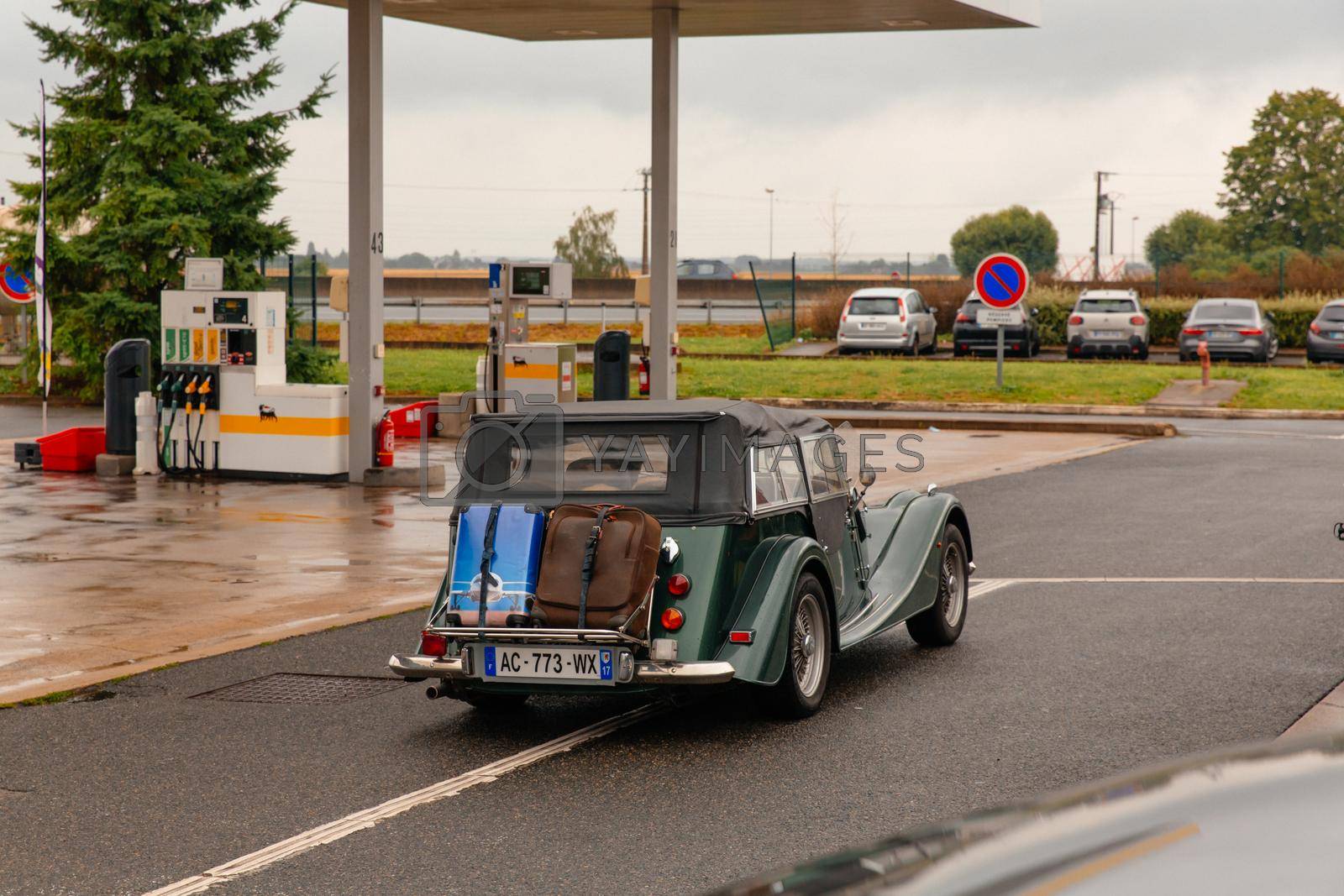 Royalty free image of Paris, France-June,10 2021: Retro car with luggage. Petrol station. Fuel business by RecCameraStock