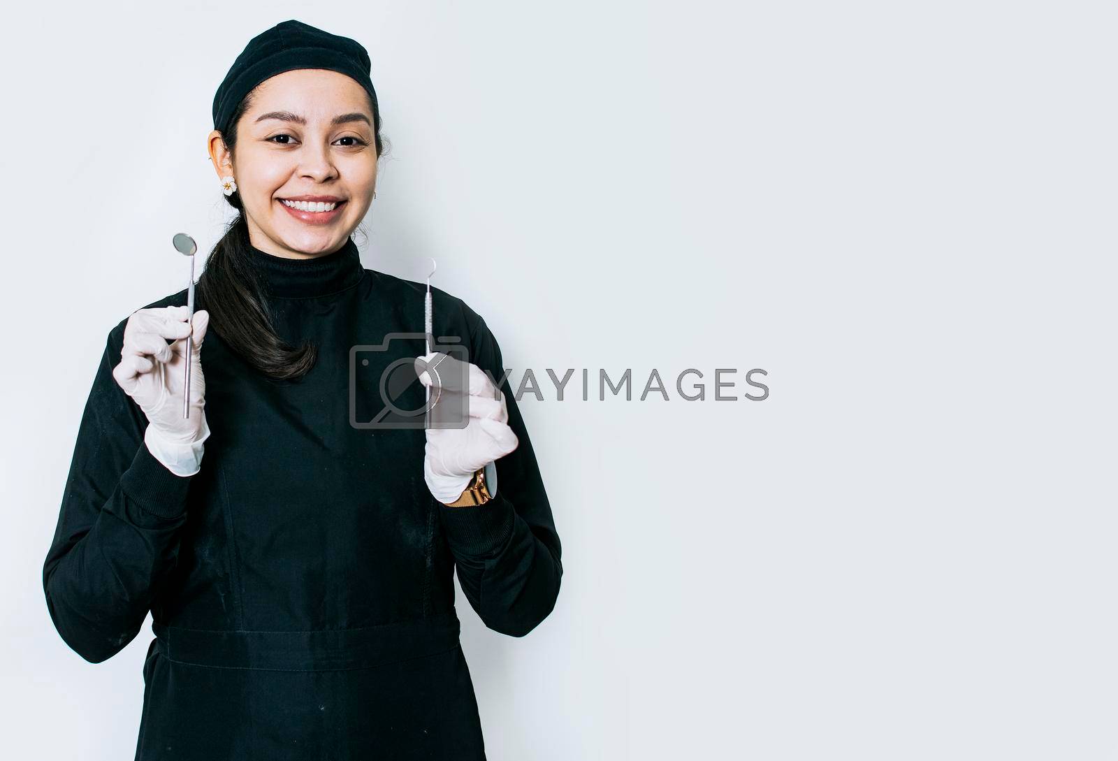 Portrait of a dentist with dental tools, portrait of a female dentist with mirror and dental probe, isolated dentist woman with dental tools