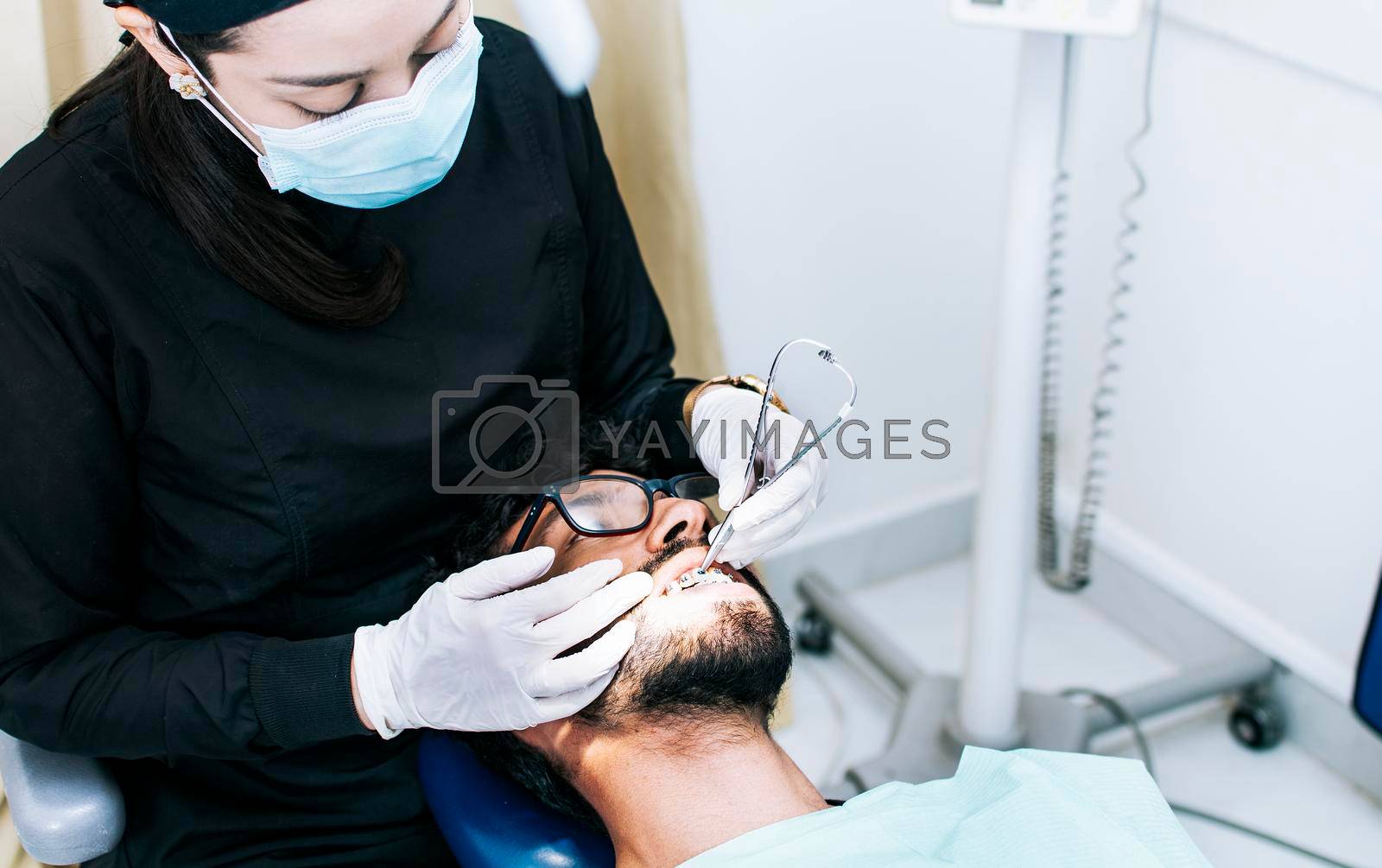 Dentist checking braces to patient, patient checked by dentist, Dentist performing dental checkup