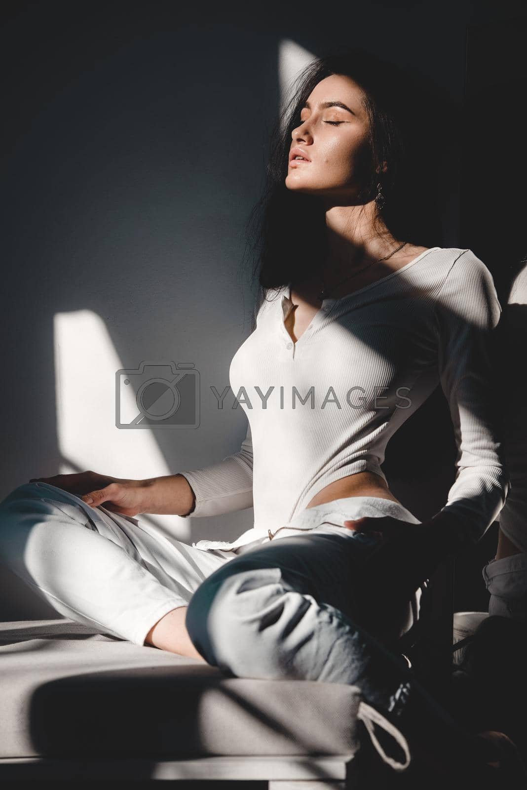 Royalty free image of portrait of beautiful gentle woman in a white bodysuit posing in the sunshine. Black long hair. sensuality and tenderness by Ashtray25