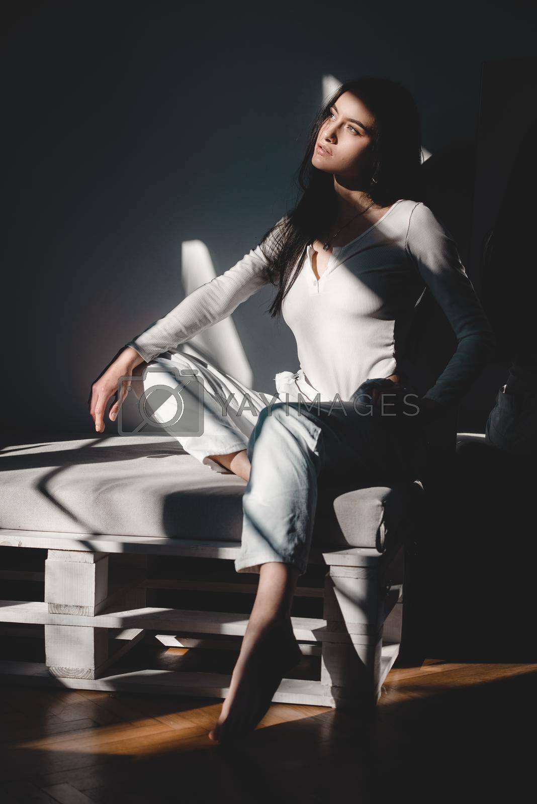 Royalty free image of portrait of beautiful gentle woman in a white bodysuit posing in the sunshine. Black long hair. sensuality and tenderness by Ashtray25