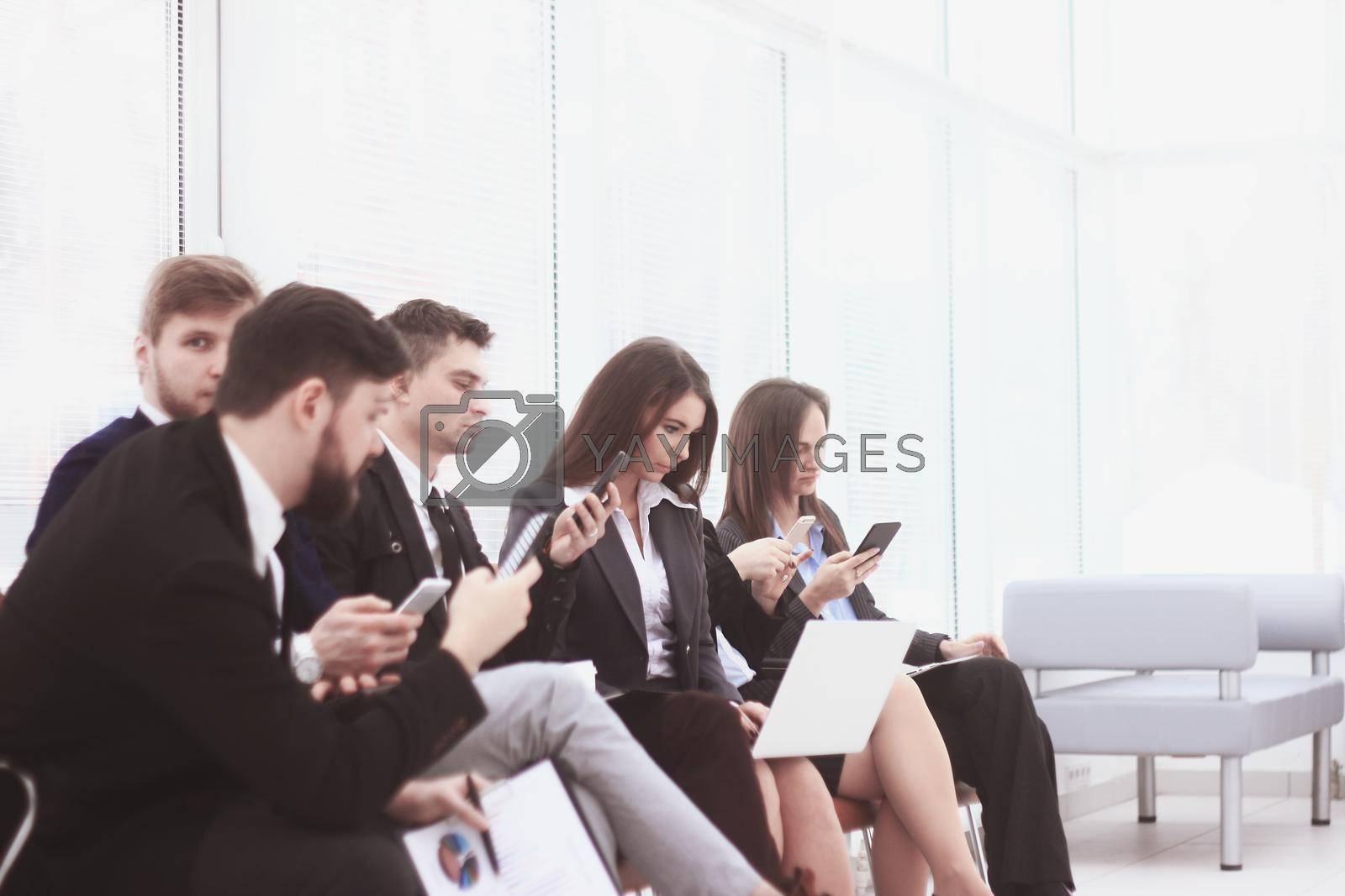 Royalty free image of business team uses laptops and smartphones while sitting in the office lobby.Internet lifestyle generation by SmartPhotoLab