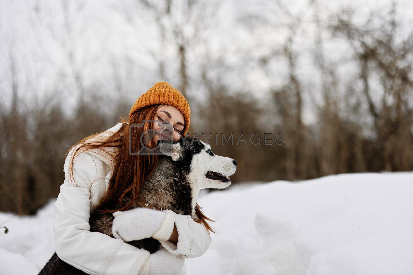 woman outdoors in a field in winter walking with a dog Lifestyle. High quality photo