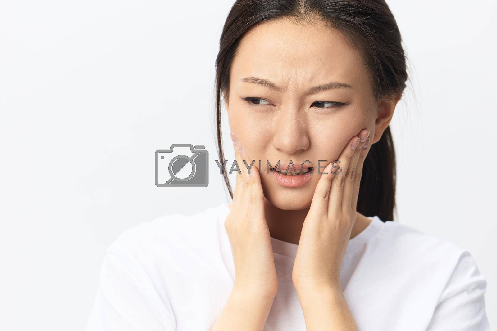 Royalty free image of Gumboil Dental abscess Wisdom teeth Periodontitis. Unhappy suffering tanned pretty young Asian woman touch cheek posing isolated on white background. Injuries Poor health Illness concept. Cool offer by SHOTPRIME