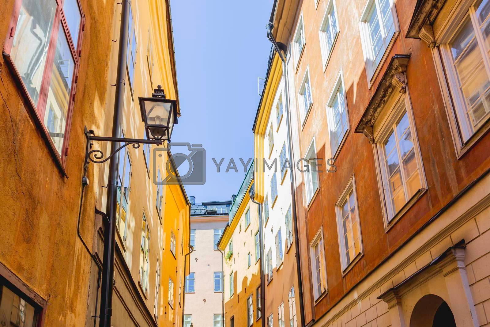 Royalty free image of Bright sun reflections on narrow street in historical part of Stockholm. Old fashioned building in Gamla stan, old part of Stockholm, Sweden. by aksenovko