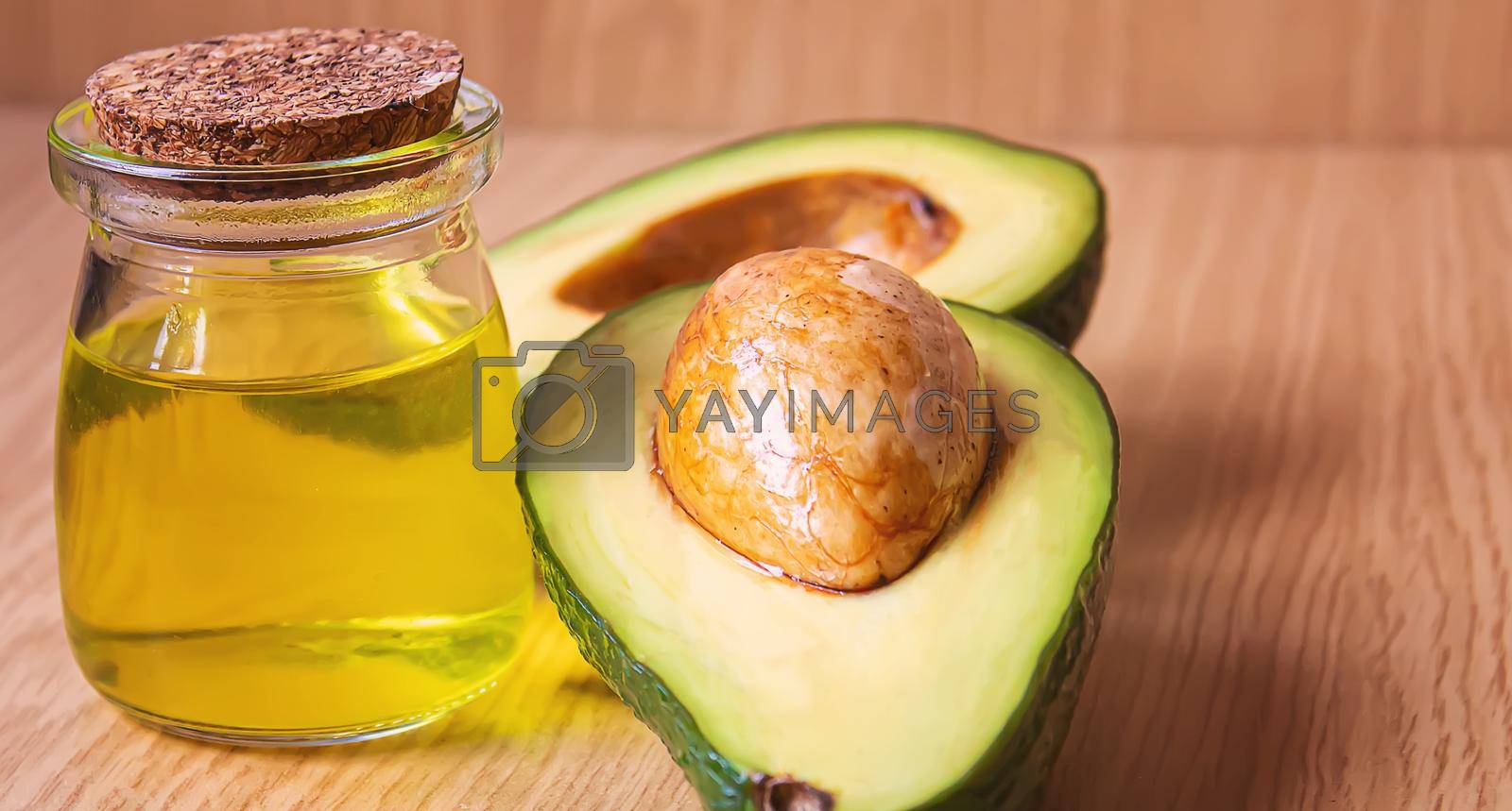 Royalty free image of Avocado and avocado oil on wooden background. Selective focus by mila1784