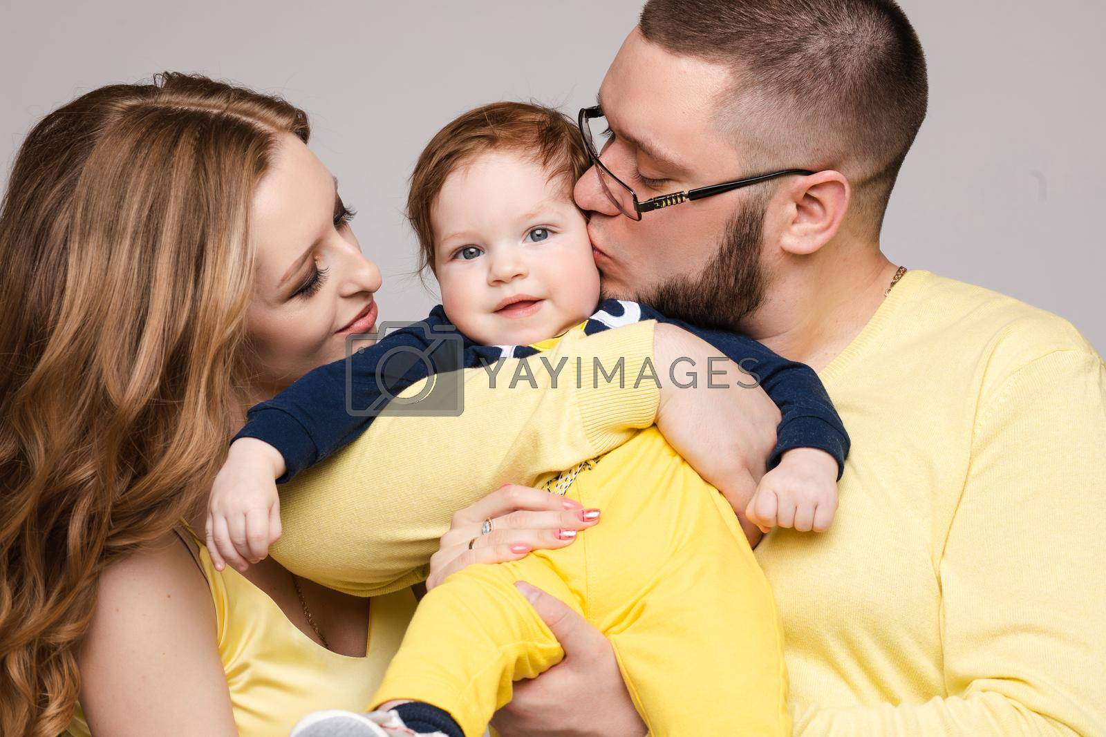 Royalty free image of Family in yellow outfit posing on isolated background by StudioLucky