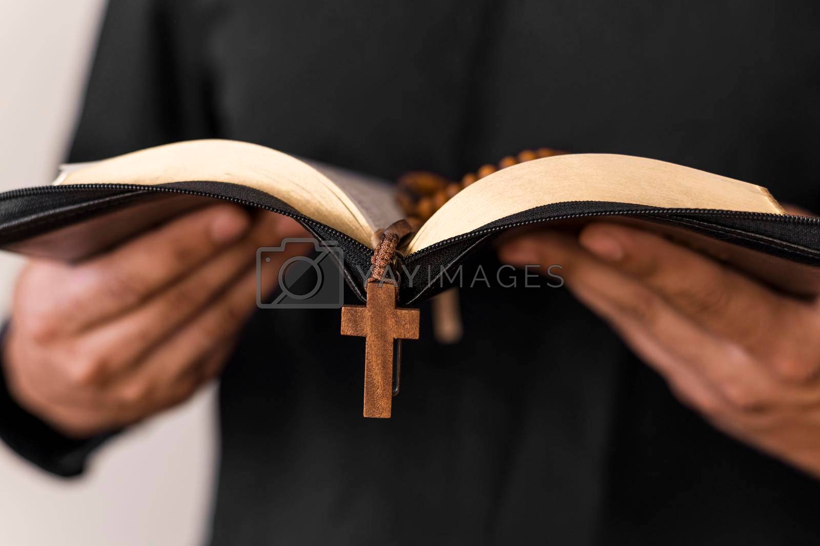 Royalty free image of front view person with holy book rosary by Zahard