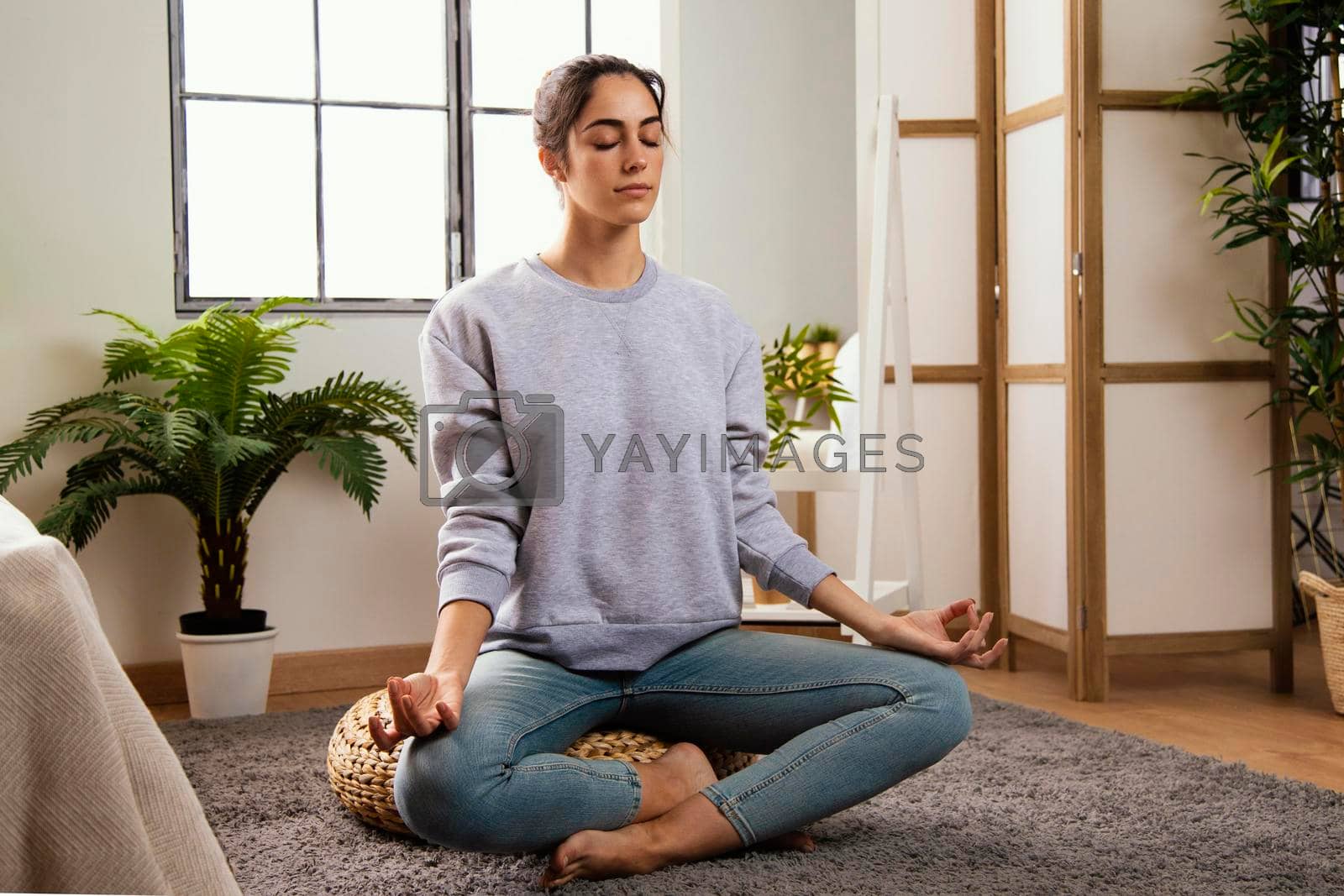 Royalty free image of front view young woman meditating home by Zahard