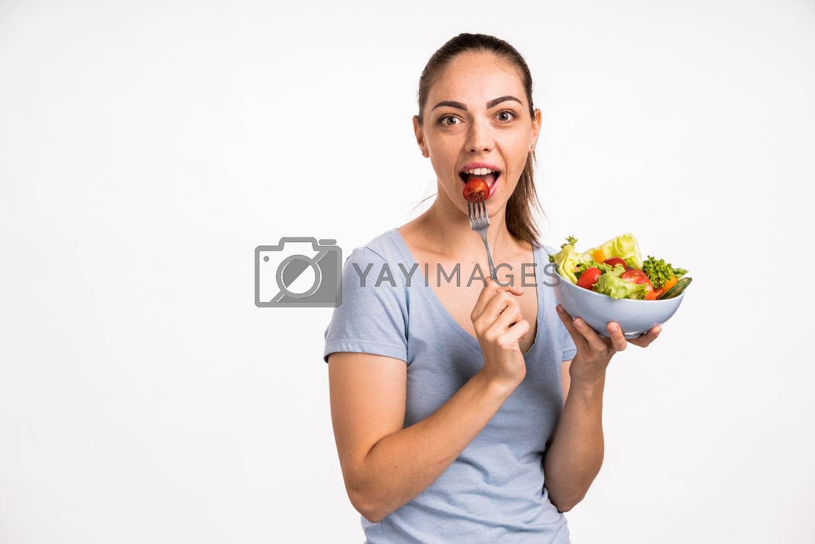 Royalty free image of woman eating tomato with fork by Zahard