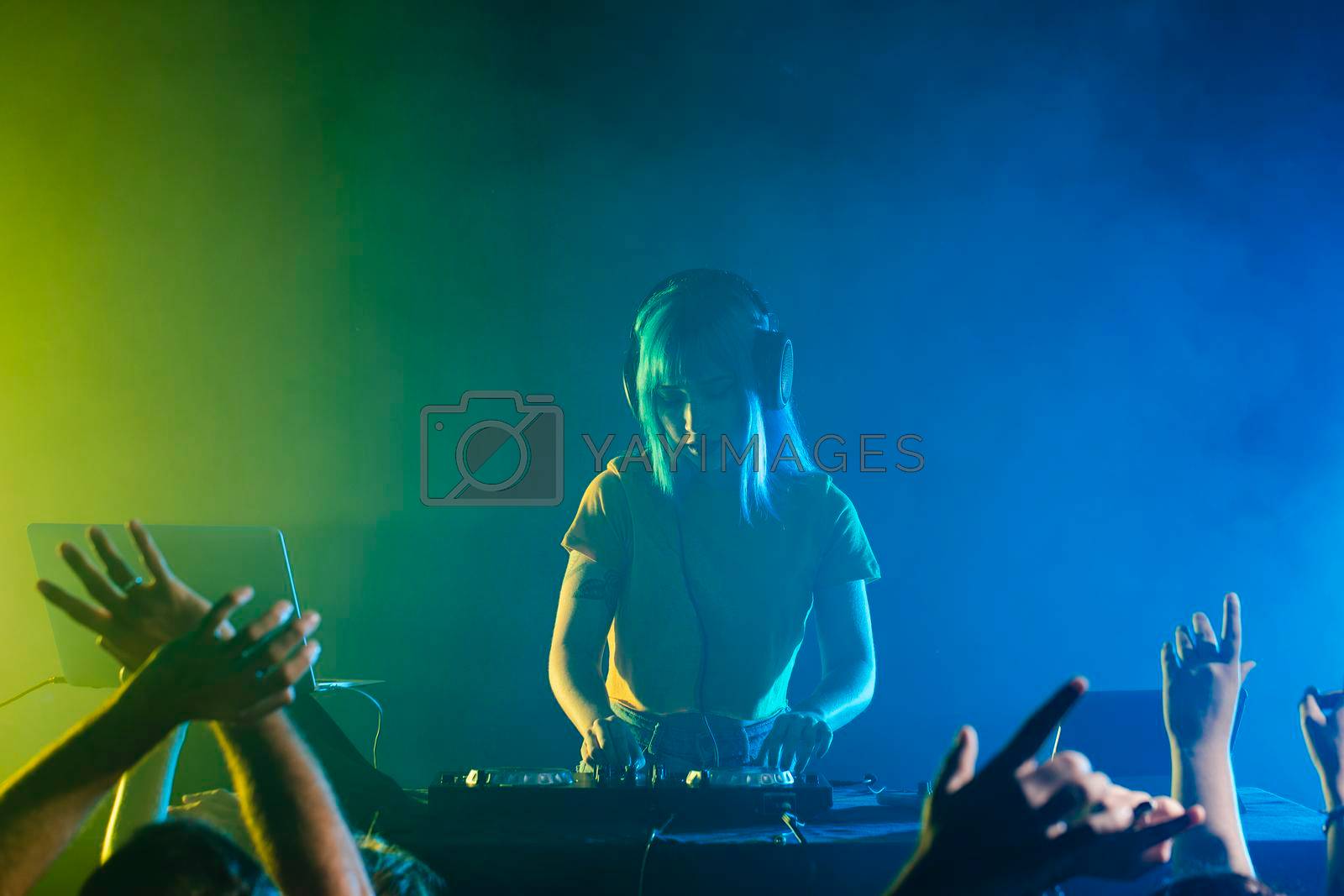 Royalty free image of clubbing with female dj mixing crowd by Zahard