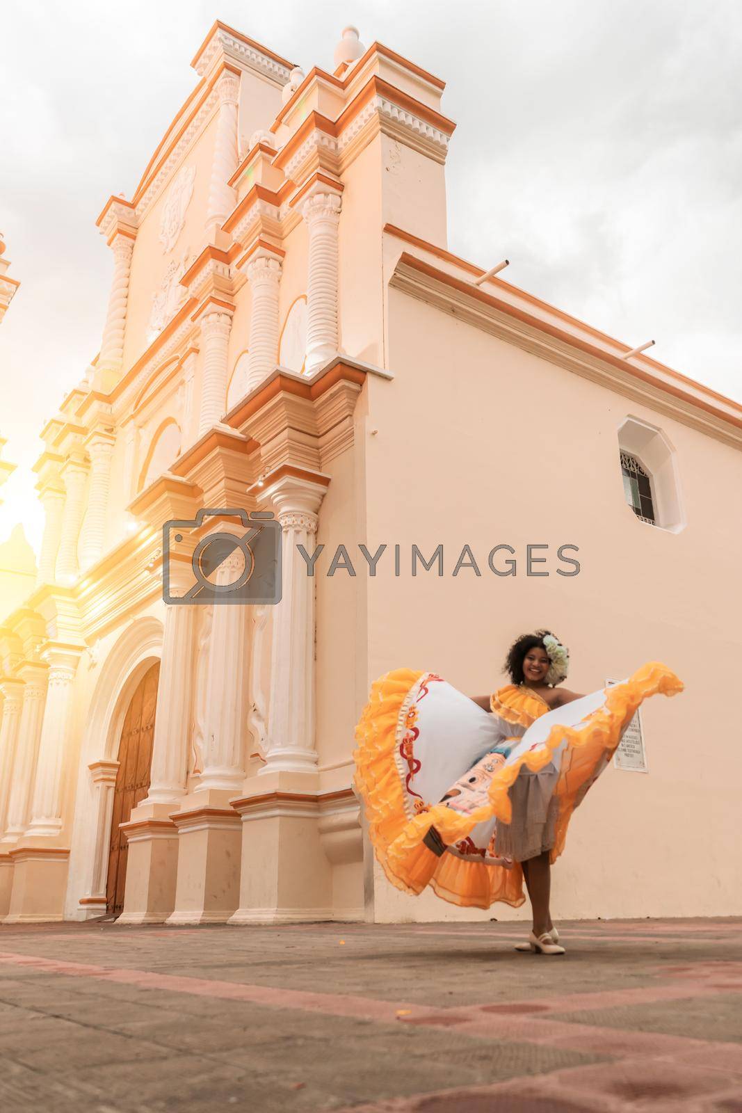 Vertical photo of a curly-haired mestizo traditional dancer with a typical Nicaraguan costume dancing outside La Merced cuhrch of Leon Nicaragua during the independence festivities of CentralAmerica.