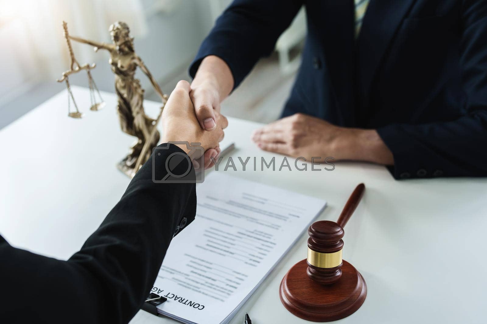 Royalty free image of Law, consultation, agreement, contract, lawyer or attorney shakes hands to agree on the client's offer to be hired to fight the parties in court. by Manastrong