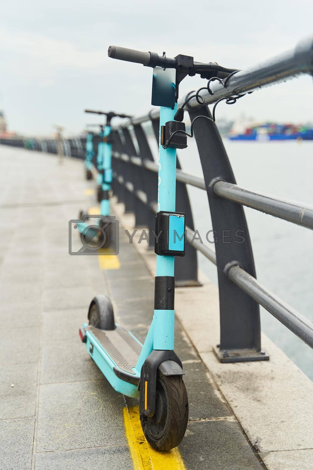 Royalty free image of Electric scooters for rent, docked on the embankment. by driver-s