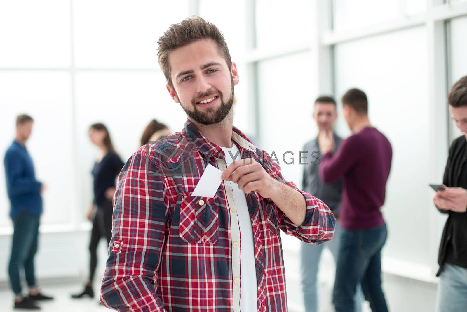 Royalty free image of successful young designer with a business card standing in the office by asdf