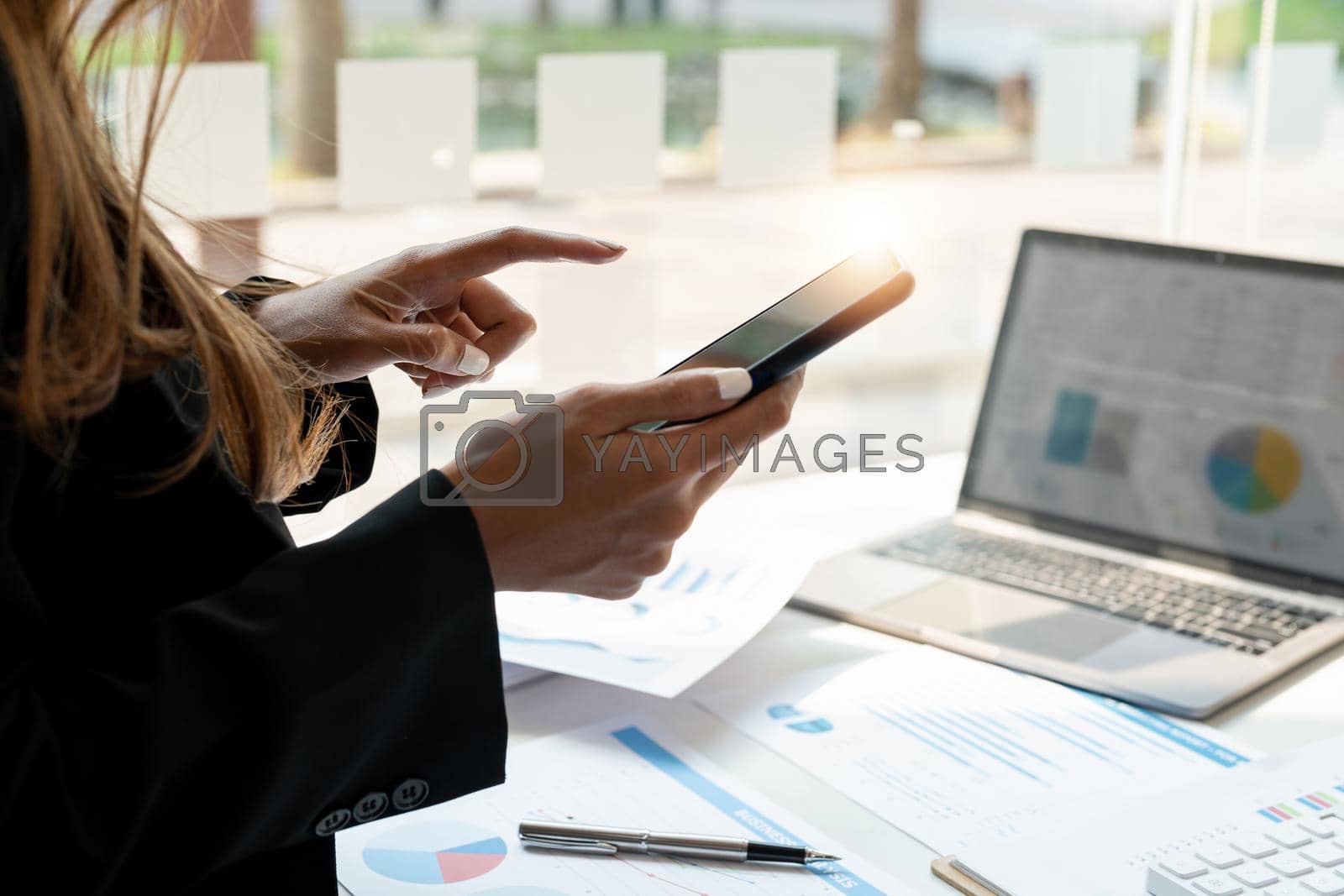 Close up business woman use of smart phone for financial accounting at office.
