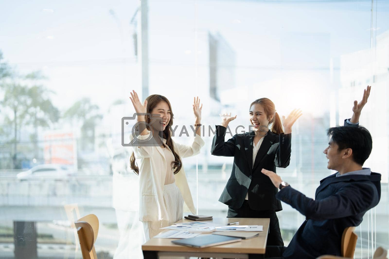 Royalty free image of Young multiethnic diverse creative asian group huddle and high five hands together in office workshop with success or empower expression in teamwork. Young asian marketing team with copy space by nateemee