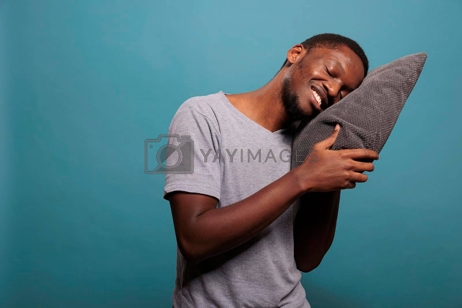 Royalty free image of Happy man putting head on comfortable pillow to sleep by DCStudio