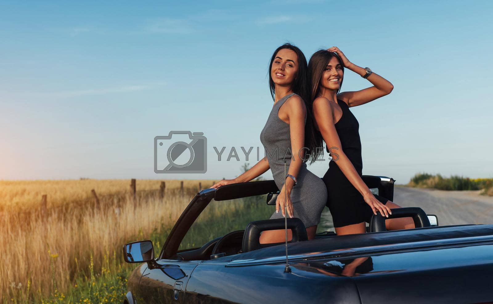 Royalty free image of Beautiful two women sitting in a convertible by Standret