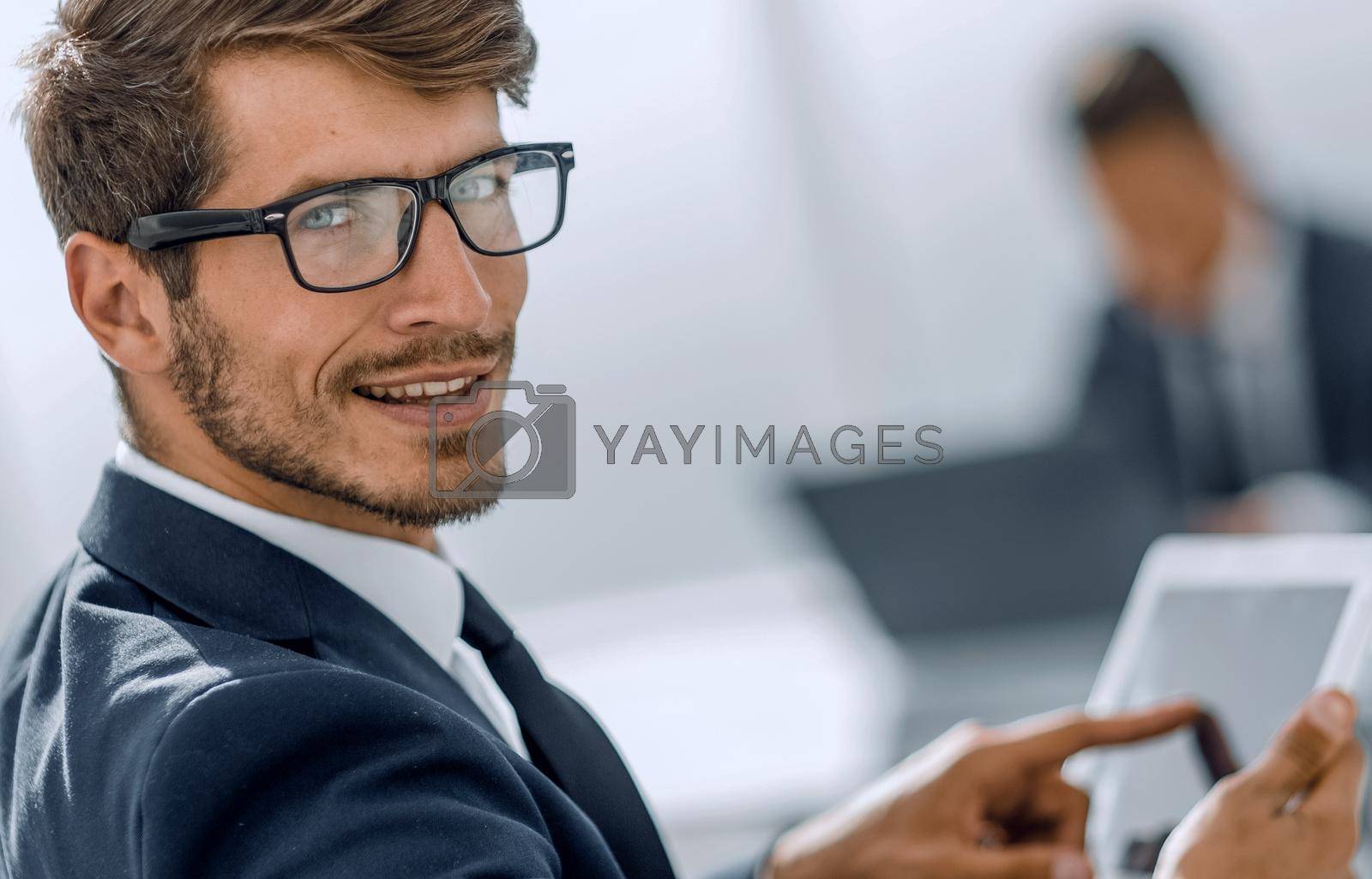 Royalty free image of man looks at camera and smiles using tablet by asdf