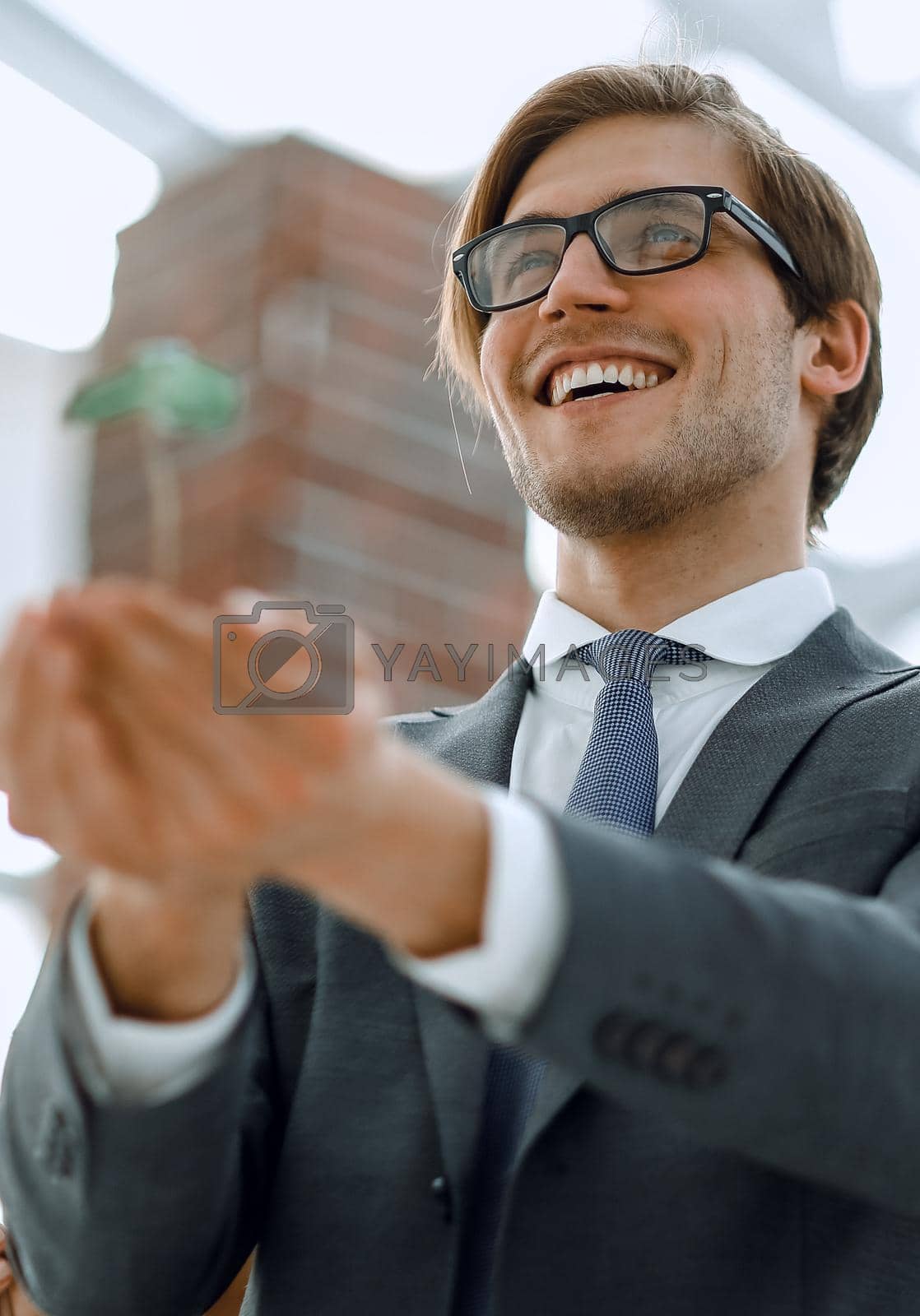Royalty free image of young businessman holds the first green shoots by asdf