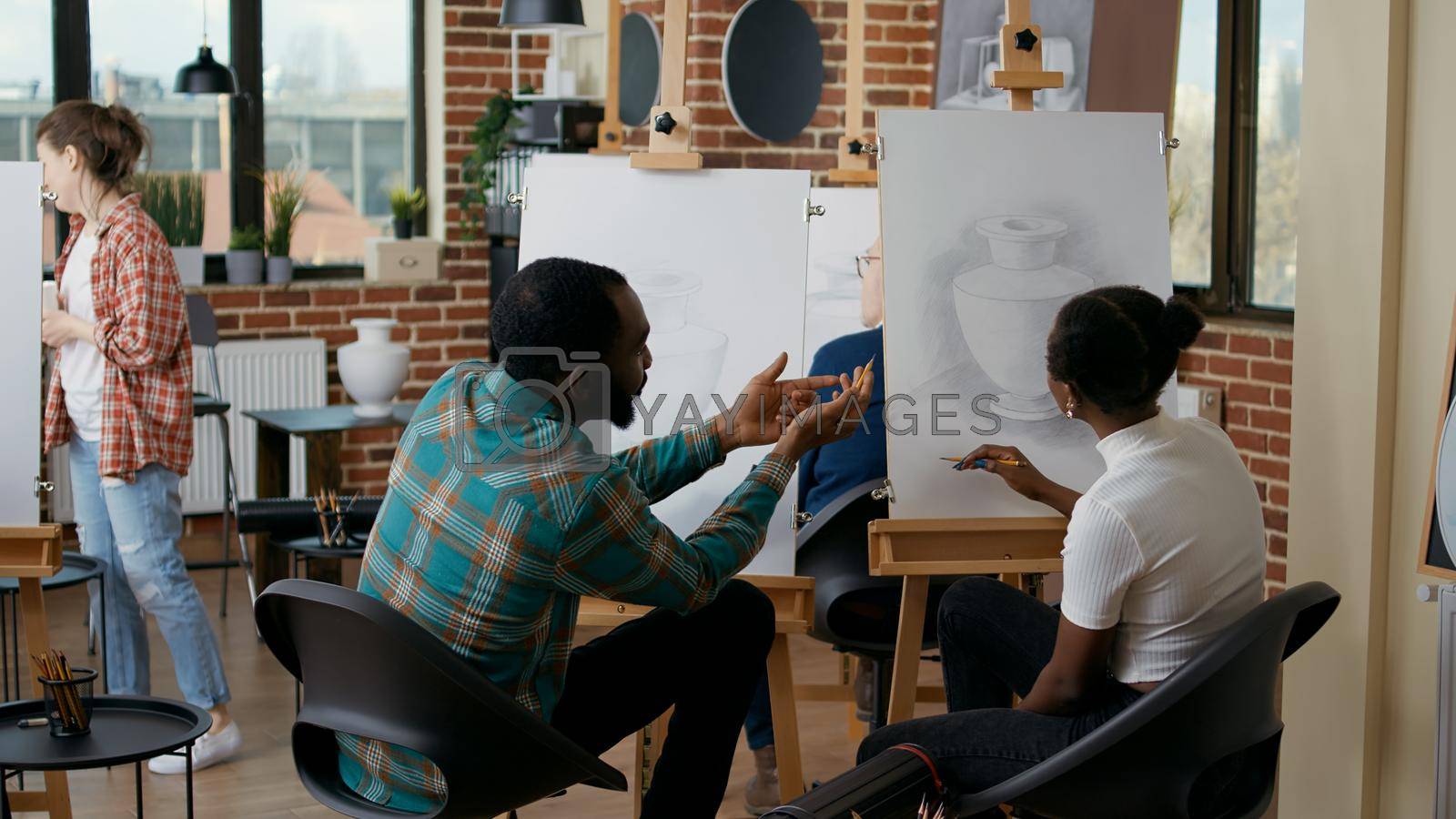 Royalty free image of Man and woman attending art class lesson to develop drawing skills by DCStudio